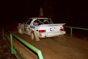 Steve Nowicki / David Stone Mazda RX-7 at speed across the final bridge on SS10, Menge Creek.