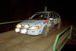 Mark Tabor / Kevin Poirier Mazda 323GTX at speed across the final bridge on SS10, Menge Creek.