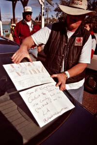 Mike Halley holds up a drawing that his daughter made of the Mitsubishi Mighty Max he and navigator Emily Burton-Weinman rolled.