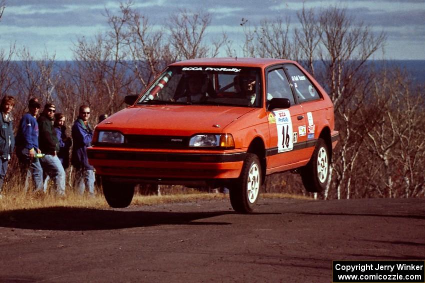 Gail Truess / Pattie Hughes Mazda 323GTX at the final yump on SS13, Brockway Mountain.