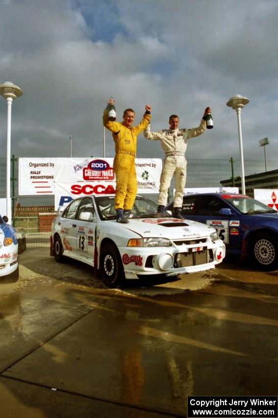 Richard Tuthill / John Bennie pose on top of their winning Mitsubishi Lancer Evo IV.