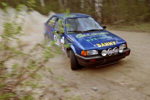 Darek Bosek / Piotr Modrzejewski drift their Mazda 323GTX through a 90-right on Indian Creek Rd., SS1.