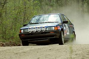 Darek Bosek / Piotr Modrzejewski limp their Mazda 323GTX through the Two Inlets State Forest with a blown right-rear tire.