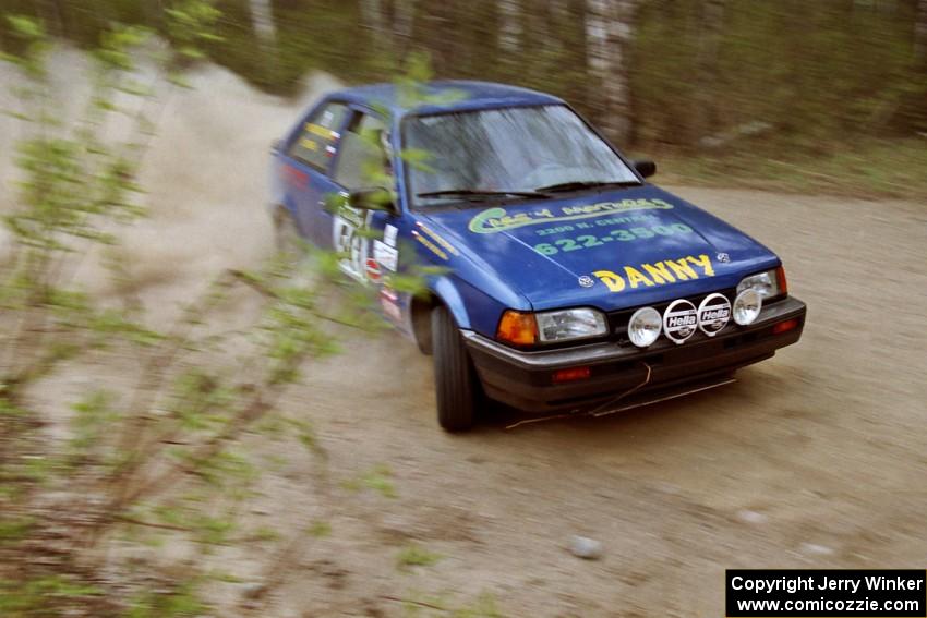 Darek Bosek / Piotr Modrzejewski drift their Mazda 323GTX through a 90-right on Indian Creek Rd., SS1.