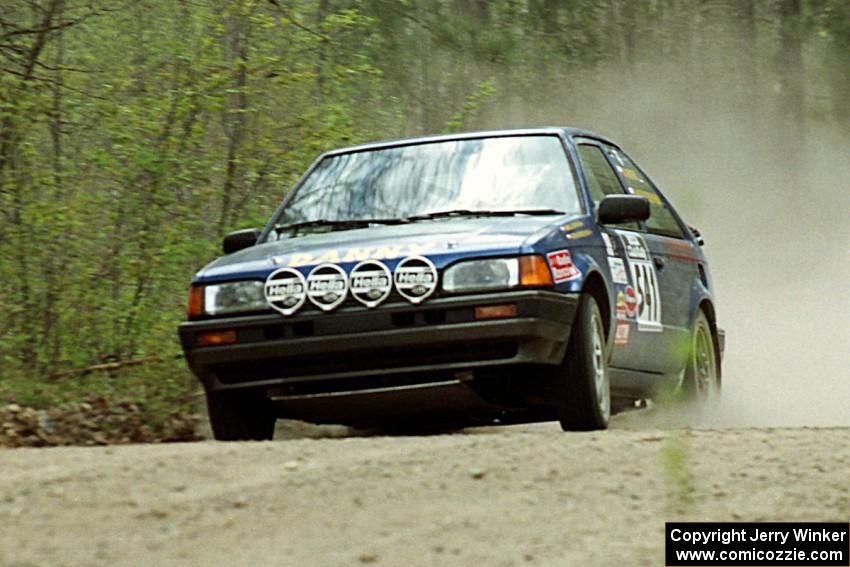 Darek Bosek / Piotr Modrzejewski limp their Mazda 323GTX through the Two Inlets State Forest with a blown right-rear tire.