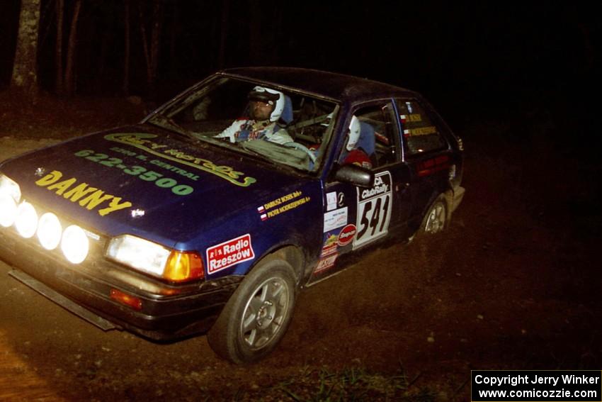 Darek Bosek / Piotr Modrzejewski head uphill at the crossroads hairpin in their Mazda 323GTX.