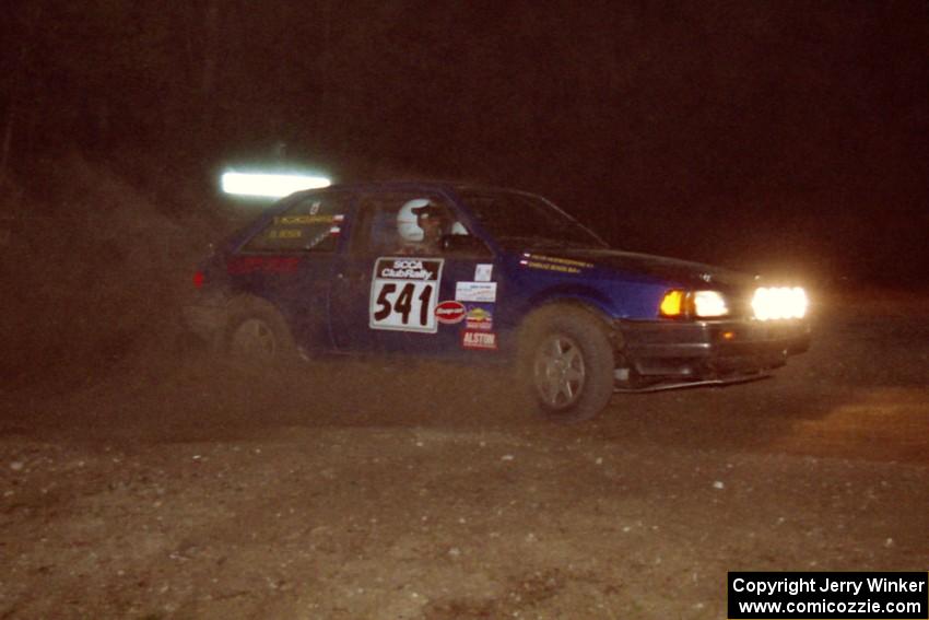 Darek Bosek / Piotr Modrzejewski drift throuigh the crossroads on the final stage of the night in their Mazda 323GTX.