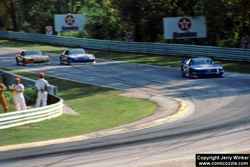 Ron Fellows' Ford Mustang ahead of Jack Baldwin's and Scott Sharp's Chevy Camaros