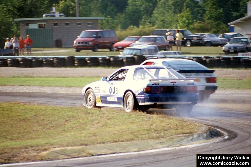 Makoto Yamamura's Mazda RX-7 loses its engine on lap two as Greg Theiss' Porsche 944 S2 passes