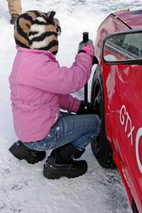 Ellie Carlson tightens lugs on the Rich Westgard / Brent Carlson Subaru Impreza