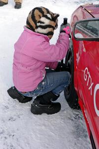 Ellie Carlson tightens lugs on the Rich Westgard / Brent Carlson Subaru Impreza