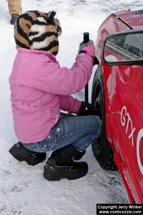 Ellie Carlson tightens lugs on the Rich Westgard / Brent Carlson Subaru Impreza