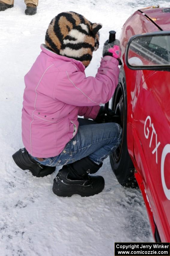 Ellie Carlson tightens lugs on the Rich Westgard / Brent Carlson Subaru Impreza