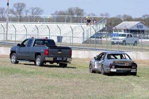 Errora Olds Aurora is towed back to the pits after losing all coolant.