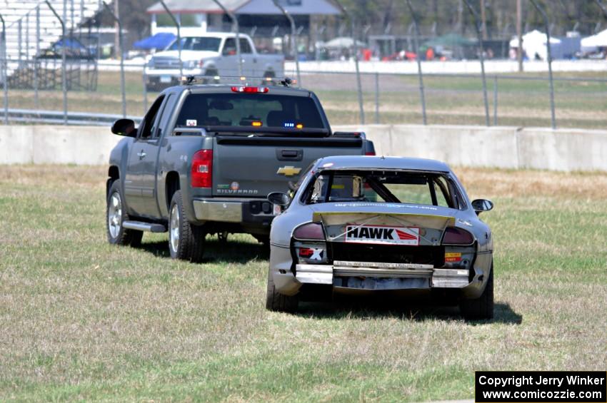 Errora Olds Aurora is towed back to the pits after losing all coolant.