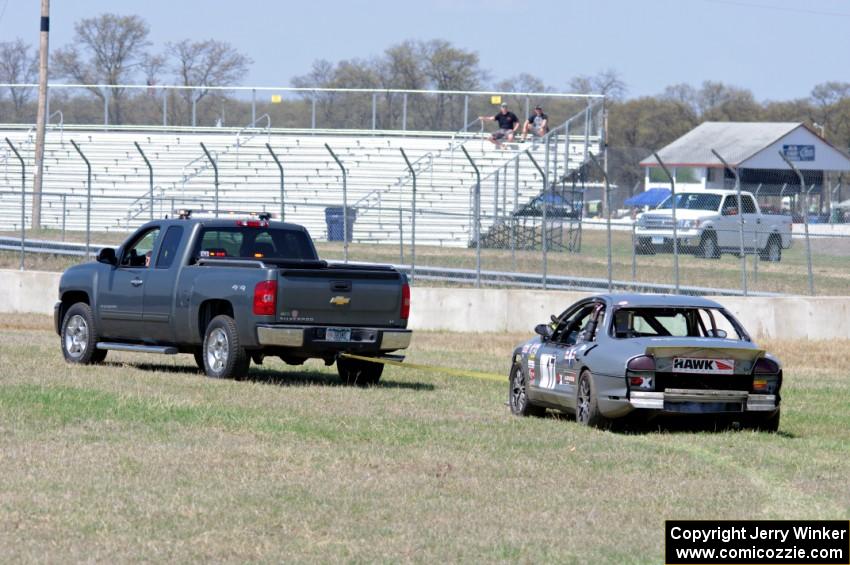 Errora Olds Aurora is towed back to the pits after losing all coolant.