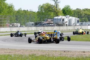 Formula cars stream through the carousel on the pace lap.