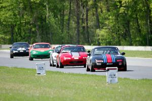 Spec Miatas stream into turn 4.