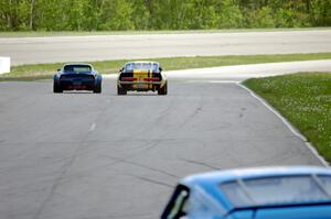 Darwin Bosell's Chevy Corvette and Shannon Ivey's Ford Mustang Shelby GT350 go side-by-side into turn one.