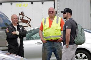 Tom Fuehrer, Jim Anderson and Will Cammack converse in the paddock area.