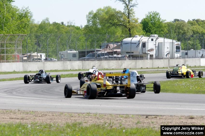 Formula cars stream through the carousel on the pace lap.