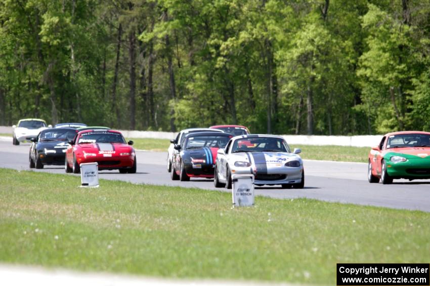 The field of Spec Miatas all bunched together into turn 4 on the first lap.