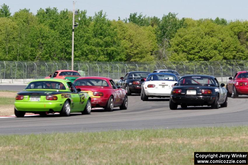 The field of Spec Miatas all bunched together at turn 4 on the first lap.