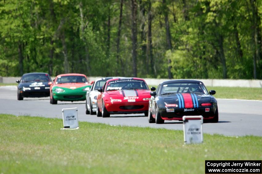 Spec Miatas stream into turn 4.