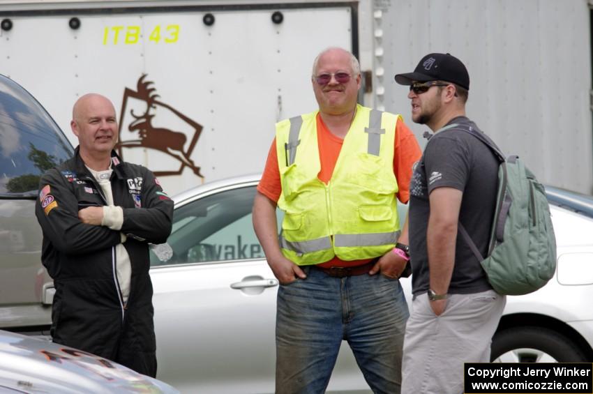 Tom Fuehrer, Jim Anderson and Will Cammack converse in the paddock area.