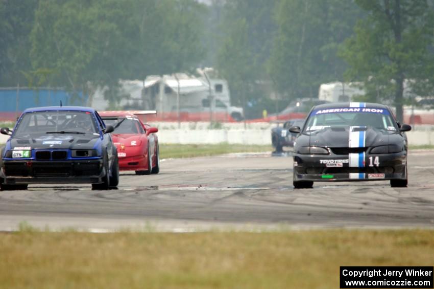 Jeff Demetri's American Iron Ford Mustang passes Terry Orr's GTS4 BMW M3 and John Boos' SU Chevy Corvette