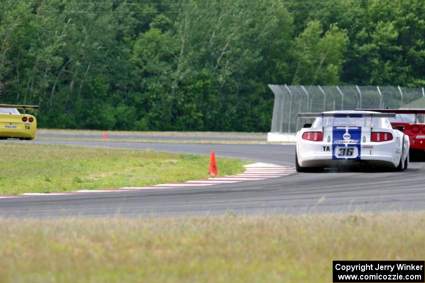 Doug Peterson's Chevy Corvette leads Amy Ruman's Chevy Corvette and Cliff Ebben's Ford Mustang