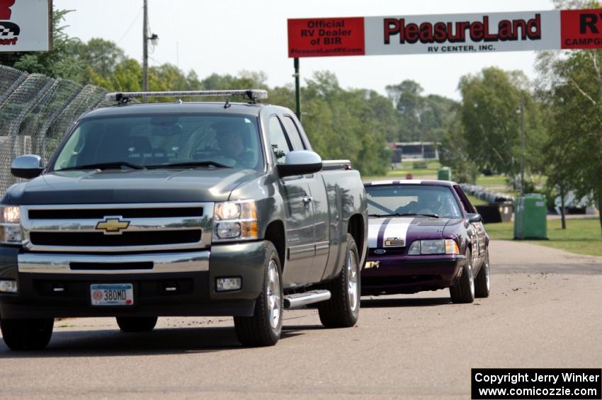 Purple-Headed Chumps Ford Mustang gets towed back to the pits.