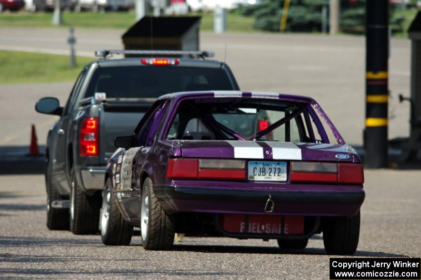 Purple-Headed Chumps Ford Mustang gets towed back to the pits.
