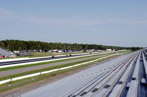 A group of cars heads down the front straight.