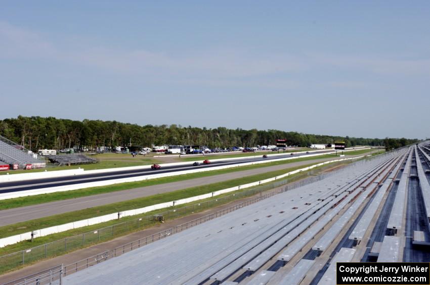 A group of cars heads down the front straight.