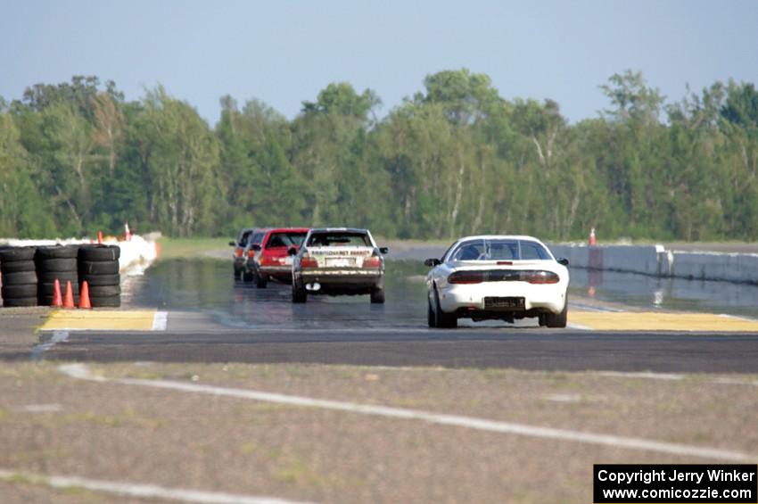 Five cars head out of turn 10 onto the front straight.