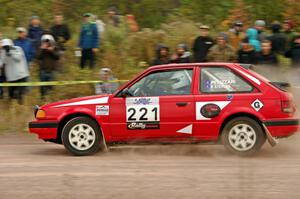 Jimmy Pelizzari / Kate Stevens Mazda 323GTX comes through the SS1 (Green Acres I) spectator area.