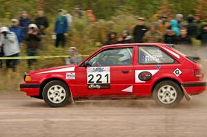 Jimmy Pelizzari / Sara Stevens Mazda 323GTX comes through the SS1 (Green Acres I) spectator area.