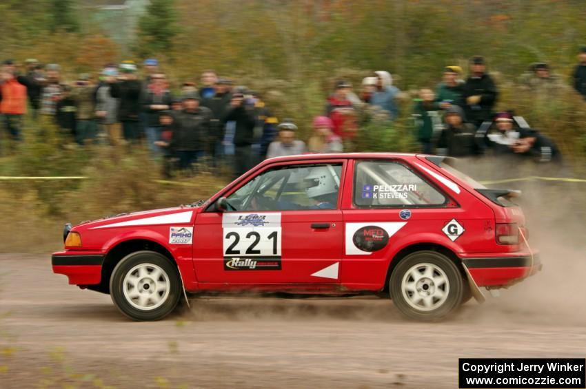 Jimmy Pelizzari / Kate Stevens Mazda 323GTX comes through the SS1 (Green Acres I) spectator area.
