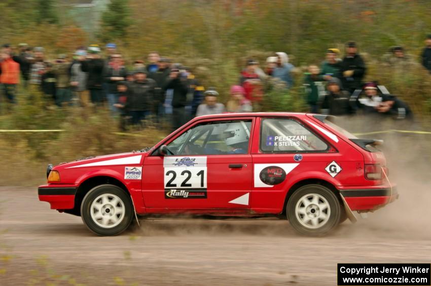 Jimmy Pelizzari / Sara Stevens Mazda 323GTX comes through the SS1 (Green Acres I) spectator area.