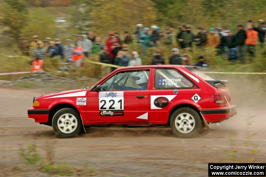 Jimmy Pelizzari / Sara Stevens Mazda 323GTX comes through the SS1 (Green Acres I) spectator area.