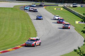Andrei Kisel's MINI Cooper leads the field through the Hurry Downs on lap one.