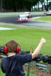 A fan at the fence gives Glenn Nixon's Honda Fit a thumbs up for winning TCB.