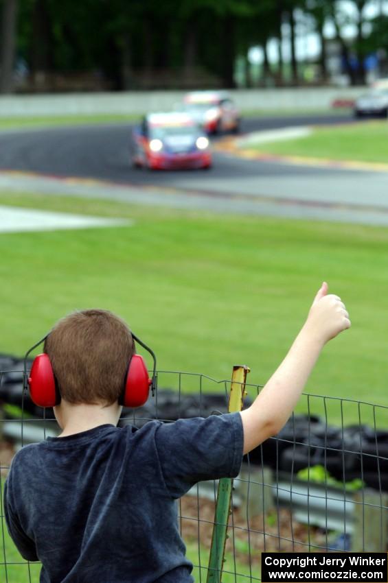 A fan at the fence gives Glenn Nixon's Honda Fit a thumbs up for winning TCB.