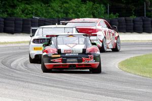 Jack Baldwin's Porsche Cayman chases Mark Wilkins' Kia Optima and Dean Martin's Ford Mustang Boss 302