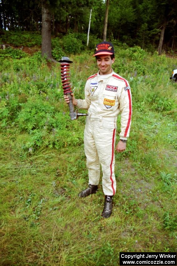 Andrew Havas displays the bent strut from his Mazda RX-7.