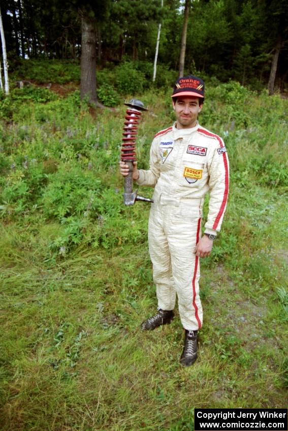 Andrew Havas displays the bent strut from his Mazda RX-7.