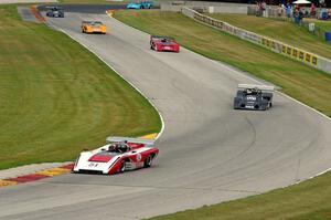 Can-Am cars stream through the Hurry Downs on lap one.