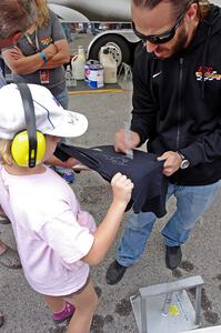 Adam Andretti signs a t-shirt for a fan.