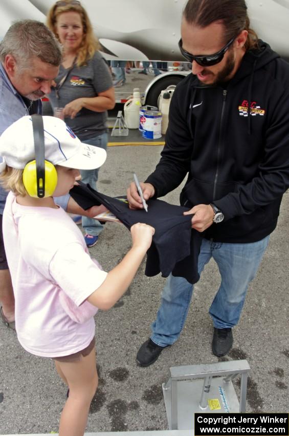 Adam Andretti signs a t-shirt for a fan.